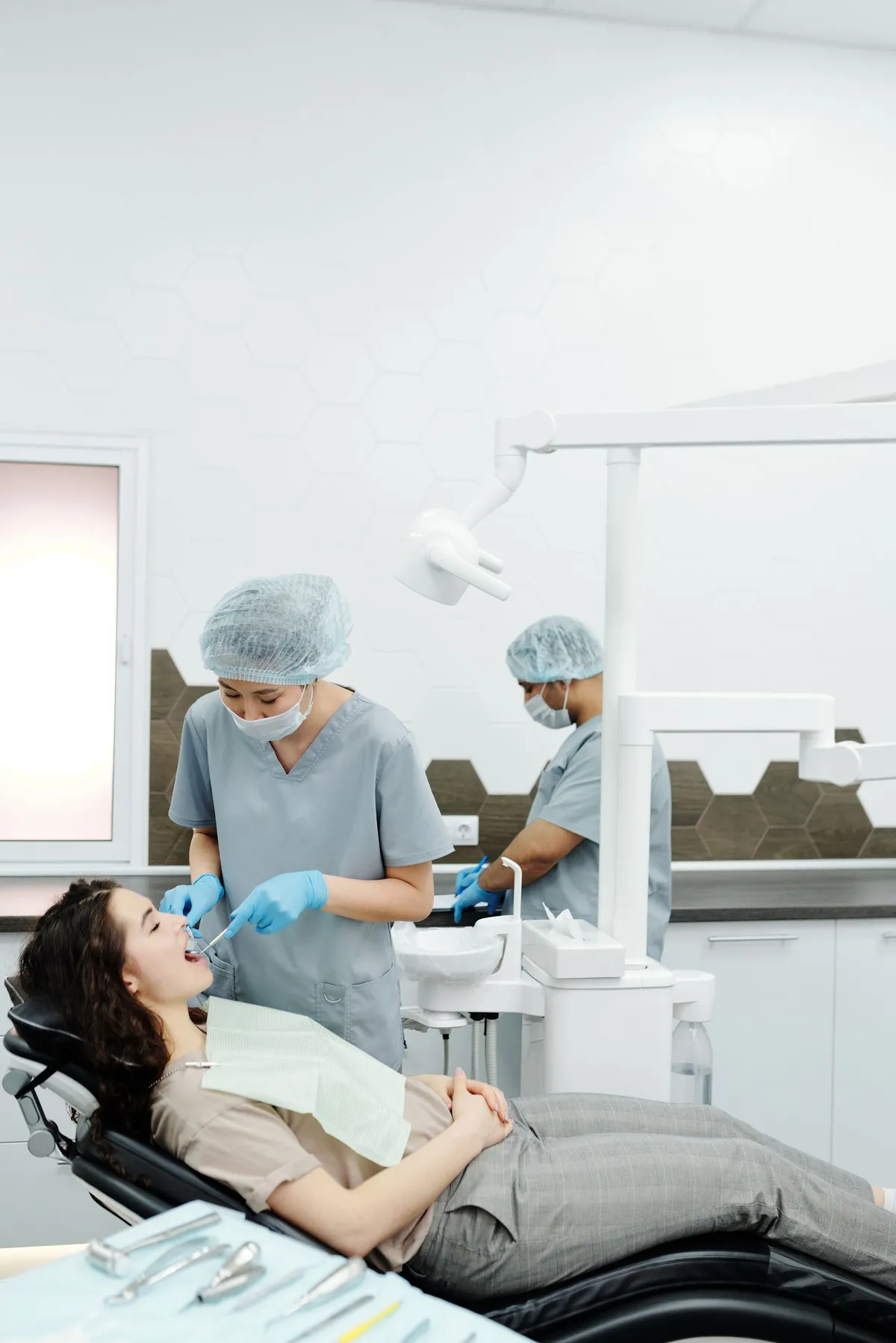 Medic stomatolog lucrând cu o pacientă în cabinet